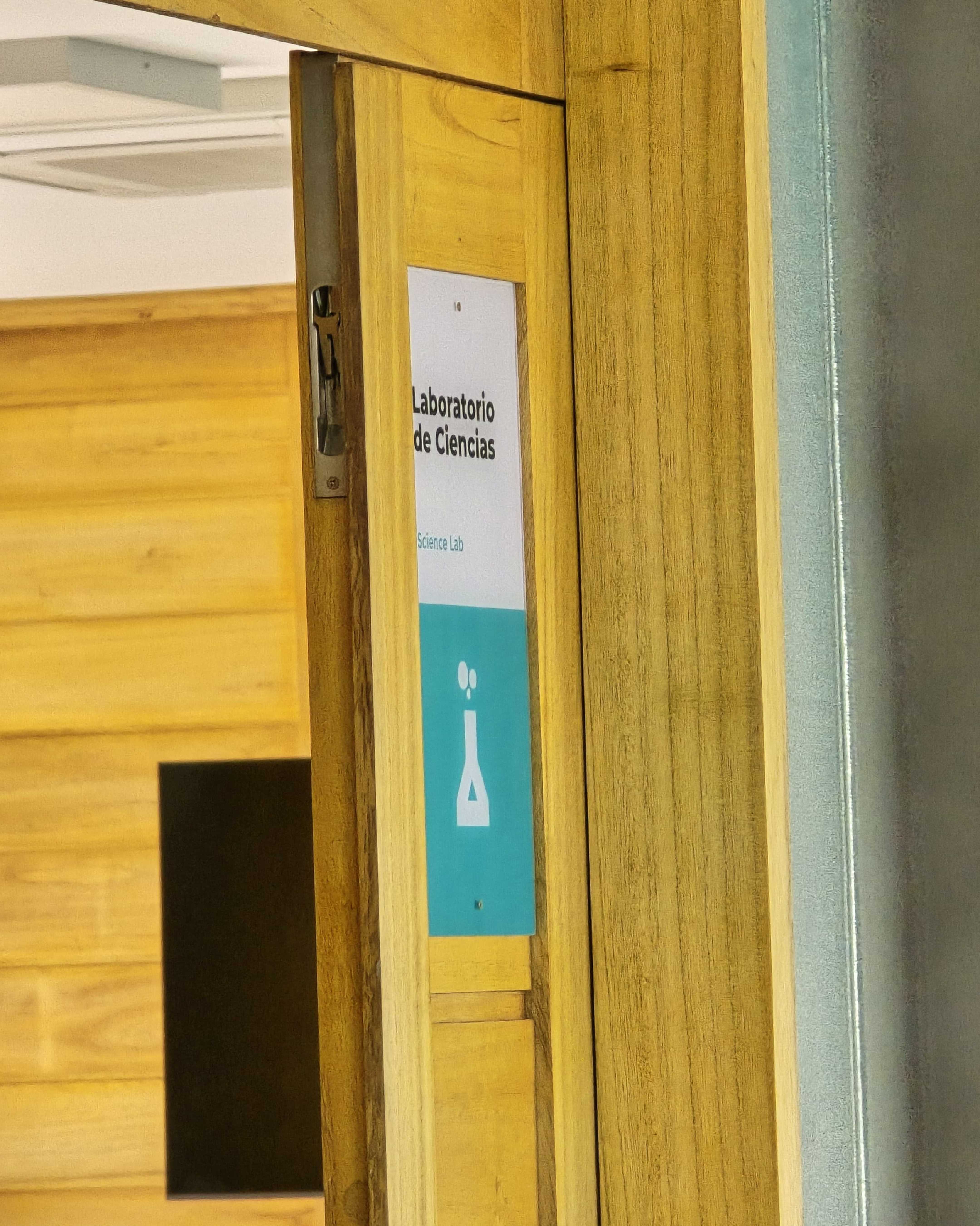 Señalética del Laboratorio de Ciencias instalada en la puerta de madera