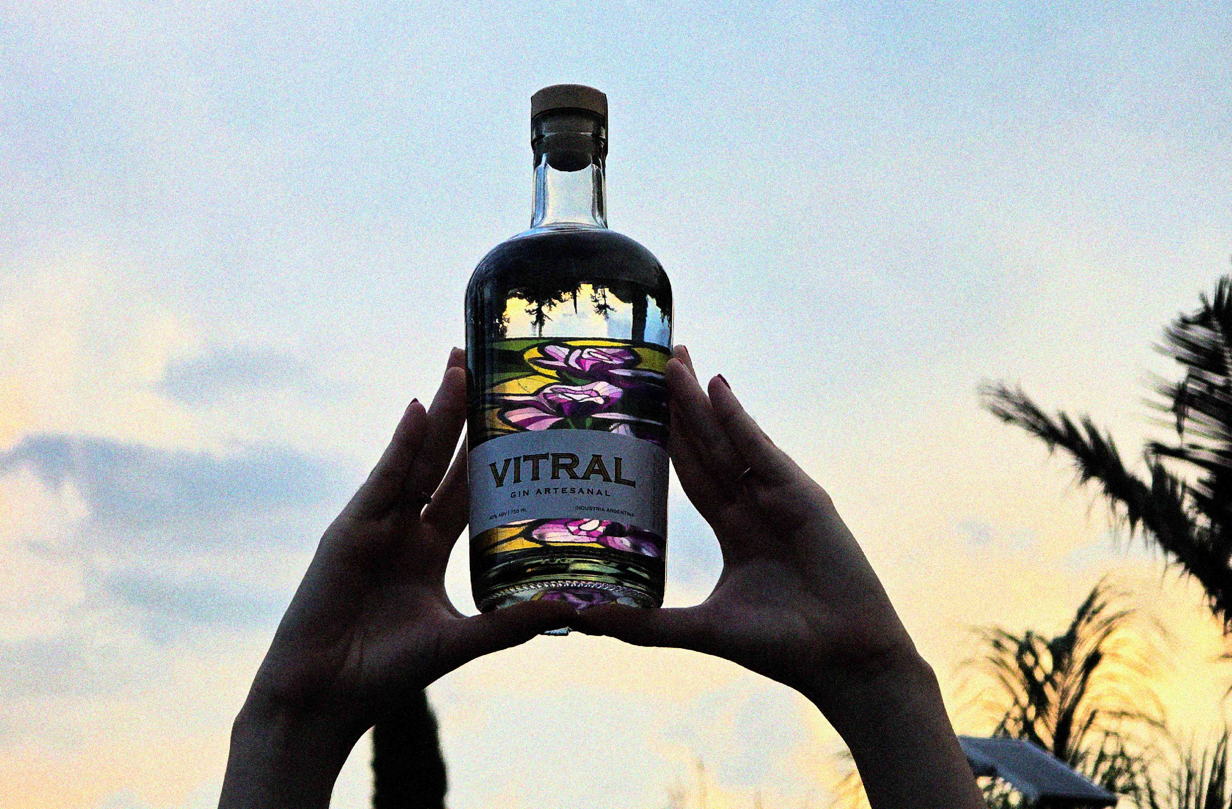 Vitral - Botella sostenida contra el atardecer mostrando efecto vitral